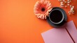 © Valentyna Prudnikova - Serene morning composition with soft peach gerbera flower, black coffee cup, and pastel pink notebook on vibrant orange background with delicate white baby's breath