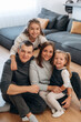 © standret - Family of four enjoying quality time together in a cozy living room, surrounded by soft furnishings and warm atmosphere, capturing moments of love and connection