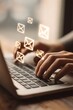 © Wida - Glowing digital mail icons float above hands typing rapidly on a modern portable computer keyboard