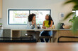 © Wavebreak Media - Diverse female friends holding coffee mugs, chatting at kitchen island with French press