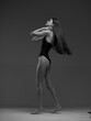 © SHOTPRIME STUDIO - Black and white image of a graceful woman standing in a bodysuit with long flowing hair and elegant posture.