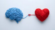 © solom - Human brain and heart made of blue and red yarn connected by a single thread on a white background representing the connection between logic and emotion or mental health balance