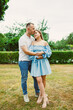 © DSMT - Couple stands in garden area during daytime while sharing a moment and embracing each other in a casual setting with green trees and grass around