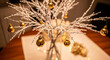© PhotoArtHub - Silver branch with gold ornament on wooden table, representing festive season, celebration, and decorative elegance for a special occasion