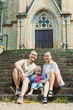© DSMT - Family sits on steps outside church on sunny day