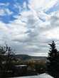 © AS Photo Family - Cloudy sky over a small town with hills and trees under a dramatic autumn landscape