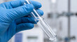 © sxcd - Scientist Hand in Blue Glove Holding Test Tube with Liquid