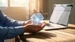 © Rahman - Hands holding holographic glowing house icon with percentage signs and laptop in background, representing real estate investment, mortgage rates, or property finance concept in warm sunlight
