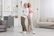 © New Africa - Happy senior couple dancing together at home