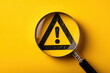 © Alena - Attention sign,Exclamation mark,warning sign concept.,Magnifying glass focus on Hazard warning attention sign icon over yellow background with copyspace
