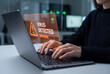 © Meow Creations - Female hands typing on laptop computer with digital virus detected warning hologram interface