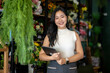 © Wasana - Female asian small business owner holding tablet