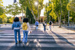 © Koldo_Studio - Multiracial students walking on a zebra crossing outside a university campus, showing diversity and education concept