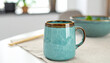© BNMK0819 - Beautiful turquoise ceramic mug with brown rim on a linen napkin, morning light, Morning vibes