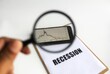 © Johari S - A hand holding magnifying glass, focused on a candlestick chart displayed on a mobile phone, with a blurred Recession text. Downtrend price movement to show the hyper inflation has started. Symbol, ic