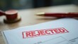 © Viktor - Close up photo shows paper with red REJECTED stamp. Pen rests near the document. Wooden gavel presents in a background. Form symbolizes professional denial and disappointment.