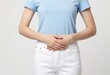 © Tino - Woman Experiencing Lower Abdominal Pain, Hands Pressing Crotch Area, Health and Wellness Concept