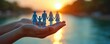 © Maryna - Paper family in hands on sunset nature background. Family love care, protection concept. Parenthood, childhood concept. Child safety, family wellbeing. Family support on health issue. Family bonding