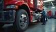 © Maryna - Red truck on careful maintenance in large industrial workshop. Mechanic stands by heavy vehicle, thoroughly checking vital parts, systems. Commercial semi truck gets pro service. Garage ensures big