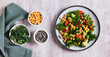 © elenarui - Mix of chickpeas, tomatoes, broccoli and parsley on a plate on the table top view web banner