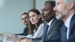 © AndyGordon - Business professionals sitting in a meeting, with a focused woman in the foreground.