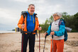 © Юлия Завалишина - Hiking tourism adventure. Senior couple man woman enjoying outdoor recreation hiking on beach. Happy old people backpackers hikers enjoy walking hike trekking tourism active vacation beauty of nature