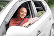 © Prostock-studio - Cheerful pretty millennial middle eastern female in hijab ride in car with driver, looks out open window, enjoy journey, outdoor, copy space. Travel in summer, weekend on road at new auto, holidays