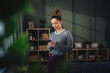 © Miljan Živković - Young woman smiling while using mobile phone at home