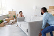 © Prostock-studio - Positive millennial african american family carry sofa to new apartment with cardboard boxes. Teamwork, rearrangement of furniture, apartment renovation, new design and relocation at home, free space