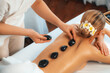 © InfiniteFlow - Hot stone massage at spa salon in luxury resort with day light serenity ambient, blissful woman customer enjoying spa basalt stone massage glide over body with soothing warmth. Quiescent