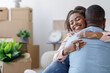 © Prostock-studio - Satisfied young black family hugging, hold key and enjoy buying real estate in room with cardboard boxes and plants. Couple excited by relocation in new house. Move day, new life, housing improvement