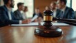 © Vadym - Gavel rests on a wooden table in a courtroom. Team of lawyers discuss documents. Law and justice concept. Legal professionals work on legal case. Advocates debate law. Court session is in progress.