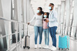 © Prostock-studio - African American Family In Medical Masks Standing In Airport Terminal, Holding Suitcases, Passports And Tickets, Looking At Window, Waiting For Departure, Travelling Together During Covid Pandemic