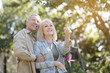 © Prostock-studio - Tender senior spouses walking in their garden, enjoying warm spring day outdoors, man embracing his wife, woman pointing away and smiling, copy space