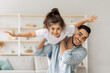© Prostock-studio - Happy middle-eastern family young handsome father and cute little daughter playing together at home, cheerful dad lifting up his joyful girl, playing airplane in living room, copy space