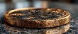 © kenzie - Close-up of a weathered gold coin's edge resting on a dark surface
