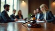 © Viktor - Lawyers in suits collaborate in a modern office. A judge gavel sits on the foreground table signifying legal proceedings or decision making. Team works on case files.