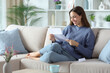 © Antonioguillem - Happy woman in blue reading paper letter at home