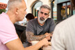 © alvaro - Friends enjoying conversation at outdoor cafe table