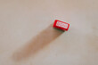© ADDICTIVE STOCK - Red done stamp on a plain surface with shadow