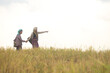 © Wosunan - Two Asian rural women walking through golden rice fields