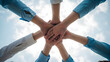 © Mounya - Teamwork and unity with hands joined together in a circle against the sky