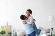 © Prostock-studio - Happy couple moving at bought house, husband lifts up beloved wife, family begin new life at first dwelling, copy space. Loan and mortgage, bank lending, relocation at own apartment, rent flat
