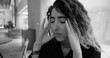 © Marco - Young woman with eyes closed and fingers on temples, stressed and emotionally drained, monochrome image representing workplace burnout and mental health challenges