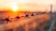 © red_orange_stock - Sunset over barbed wire fence in rural field during evening hours
