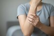 © Ramani - Forearm Pain and Discomfort Concept – Person Holding Arm in Neutral Indoor Scene, arm, forearm, pain, discomfort, strain, injury, health, muscle, wellness, symbolic, gesture, physical therapy, posture