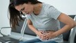 © Tino - Woman with hand pressing her lower abdomen in discomfort, showing abdominal pain and tense posture, health-focused concept