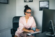 © ADDICTIVE STOCK - Woman in robe working on computer at home desk