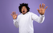 © Prostock-studio - Shocked black teen guy making protection gesture, feeling frightened on violet studio background, panorama. Terrified African American adolescent expressing emotion of fear