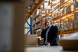 © Halfpoint - Older warehouse manager making phone call.